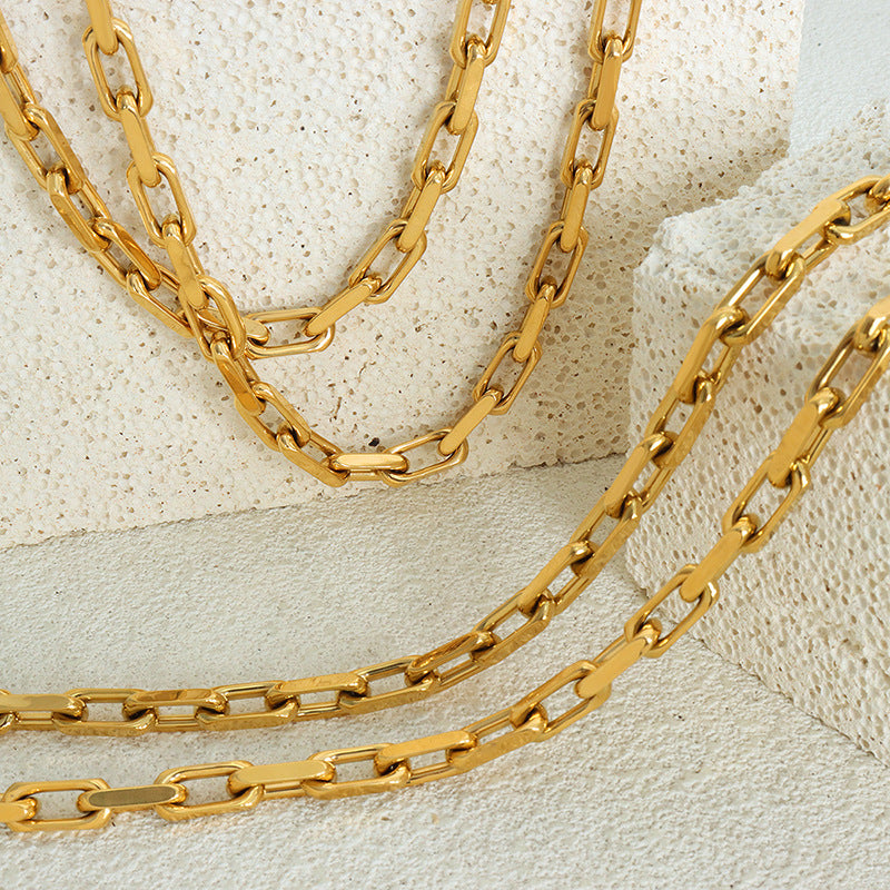 Detailed shot of the Cuban link pattern on the gold plated necklace.