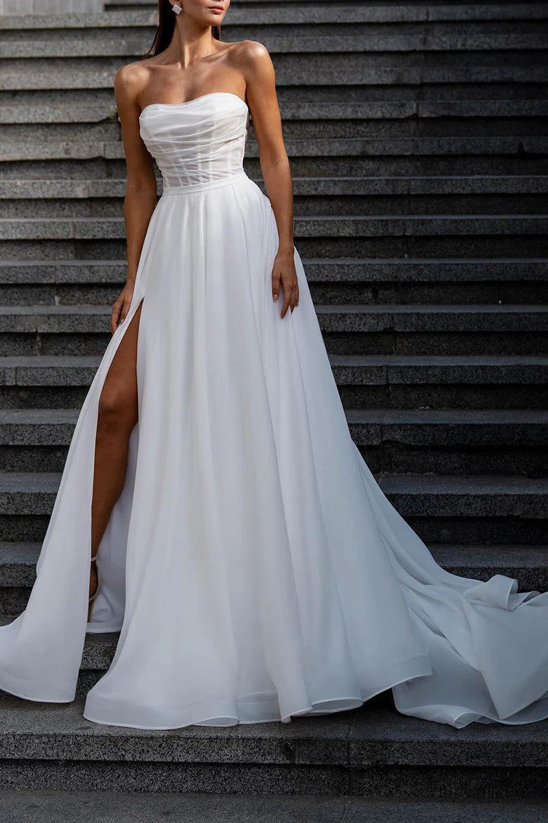 Side view of a model in an A-line boho strapless split wedding dress.