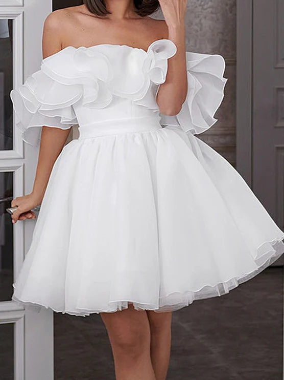Front view of a bride wearing a short A-line off-shoulder wedding dress.