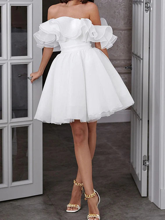Side view of a bride in a short A-line off-shoulder wedding dress.