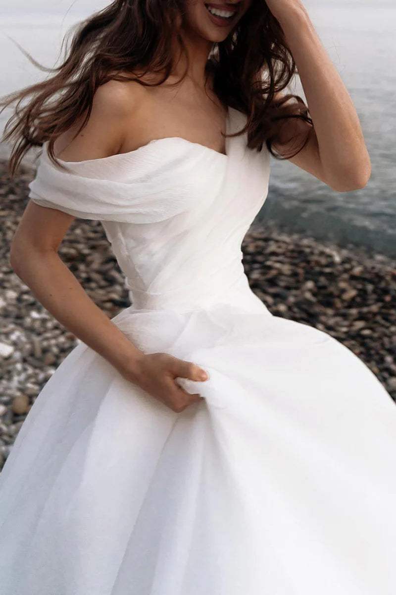 Close-up of the organza fabric and one-shoulder detail on the wedding dress.