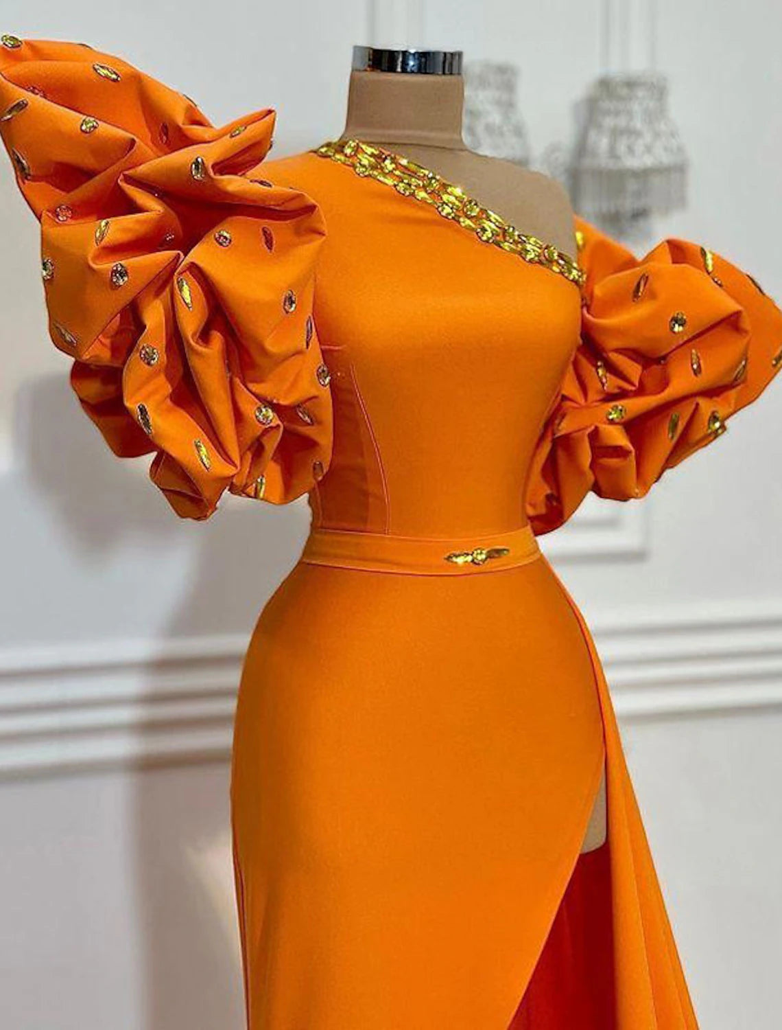Close-up of the one-shoulder neckline and intricate floral satin fabric of the evening gown.