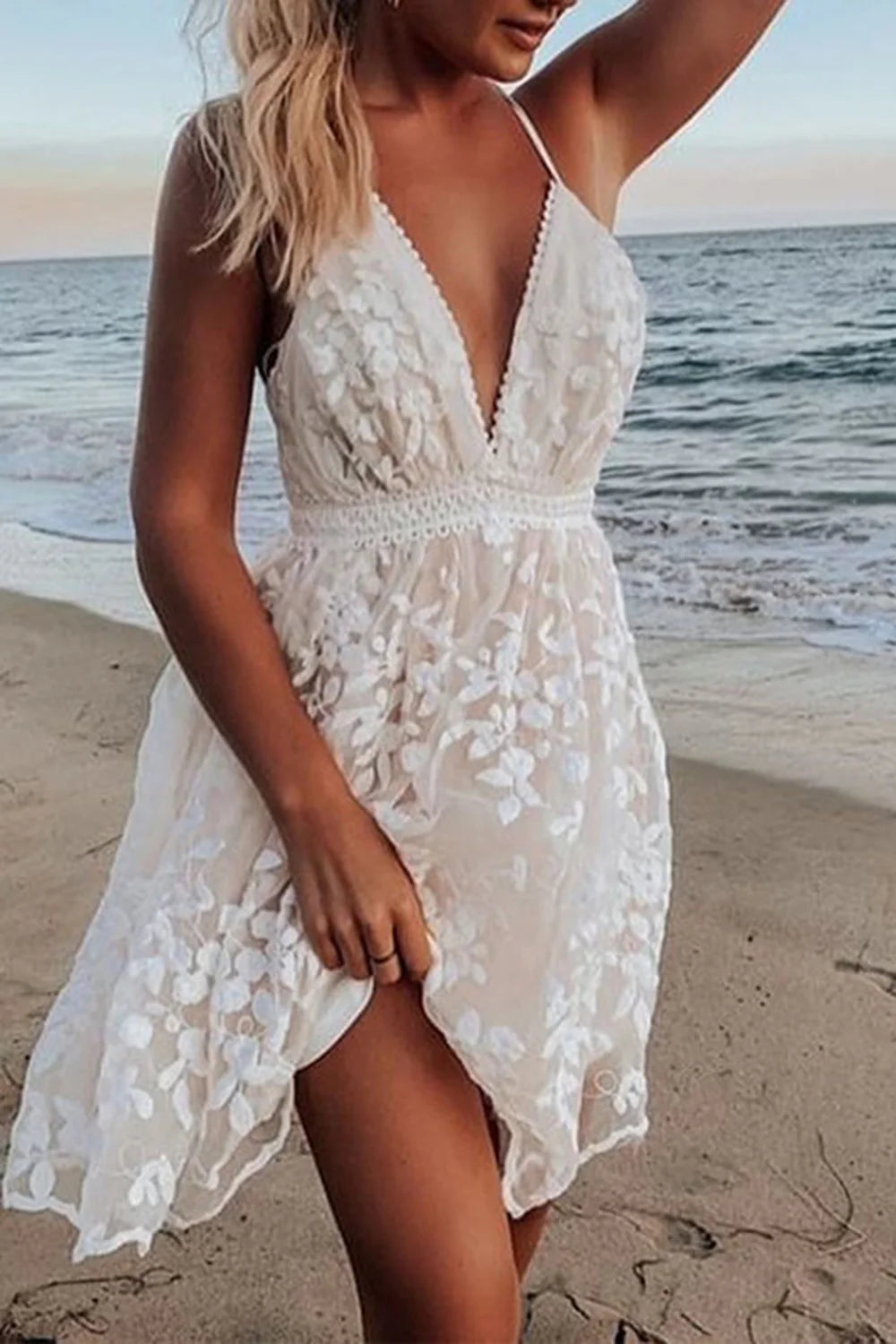 Front view of a white A-line short wedding dress with spaghetti straps.