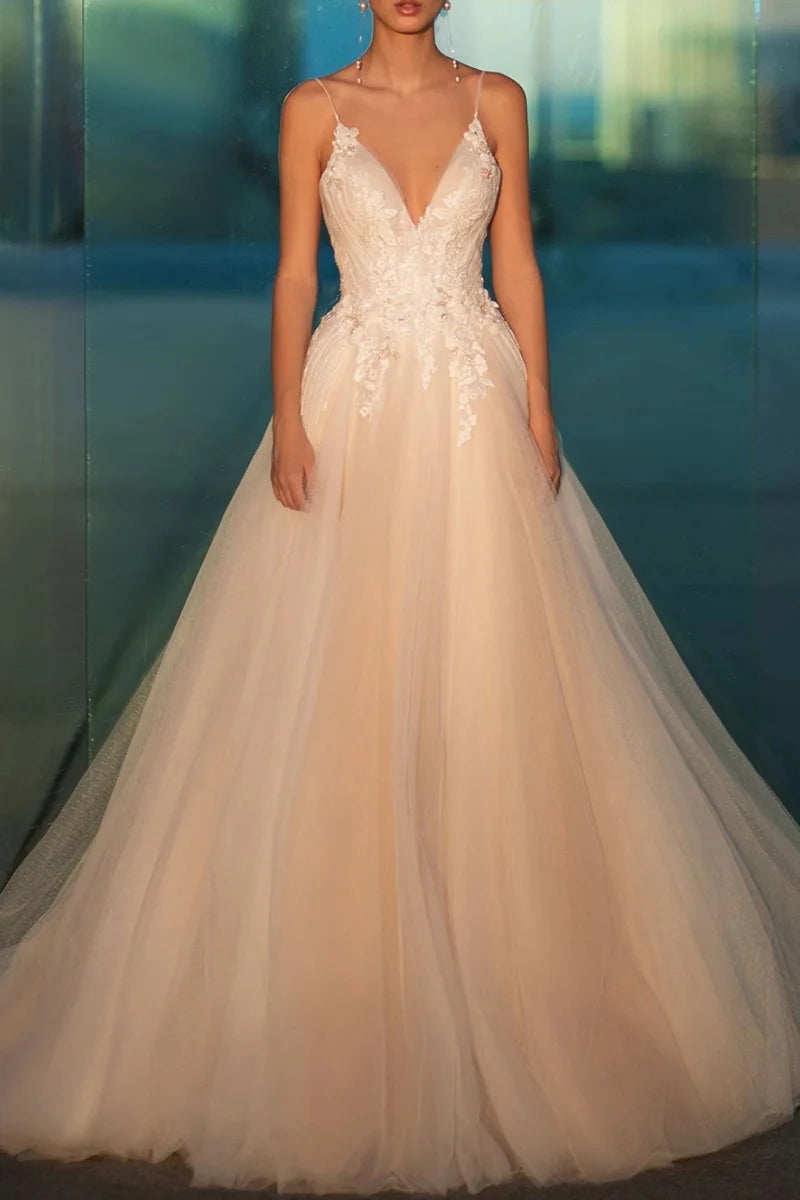 A-line wedding dress with spaghetti straps and lace appliques, front view.