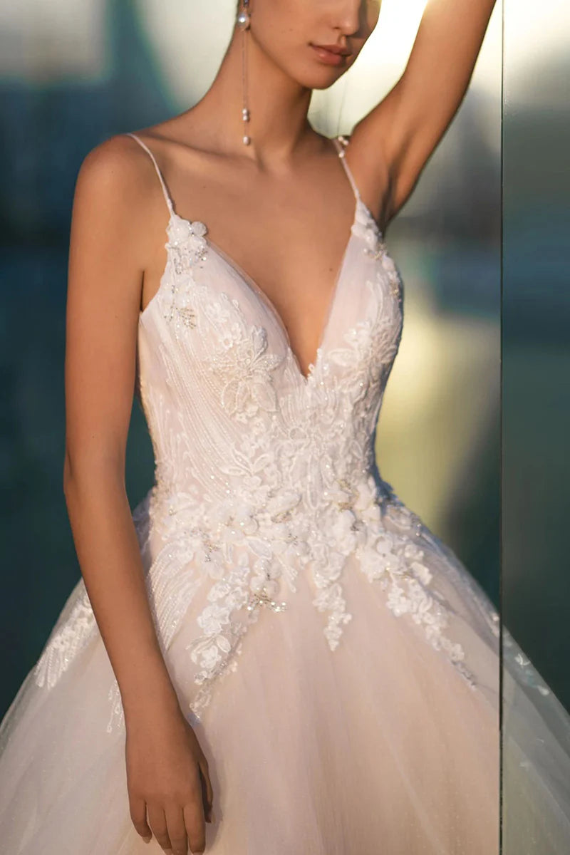 Side profile of a bride wearing an A-line spaghetti strap wedding dress.
