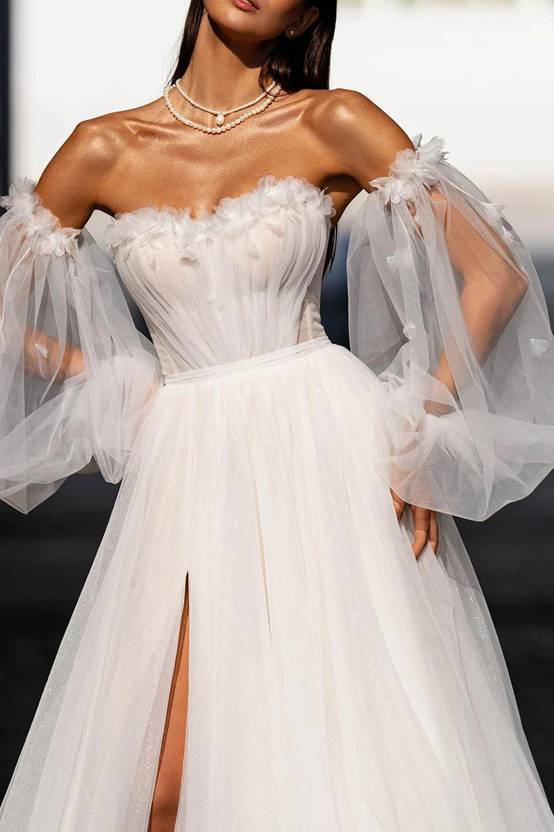 Side profile of a bride wearing an A-line wedding dress with long applique sleeves.