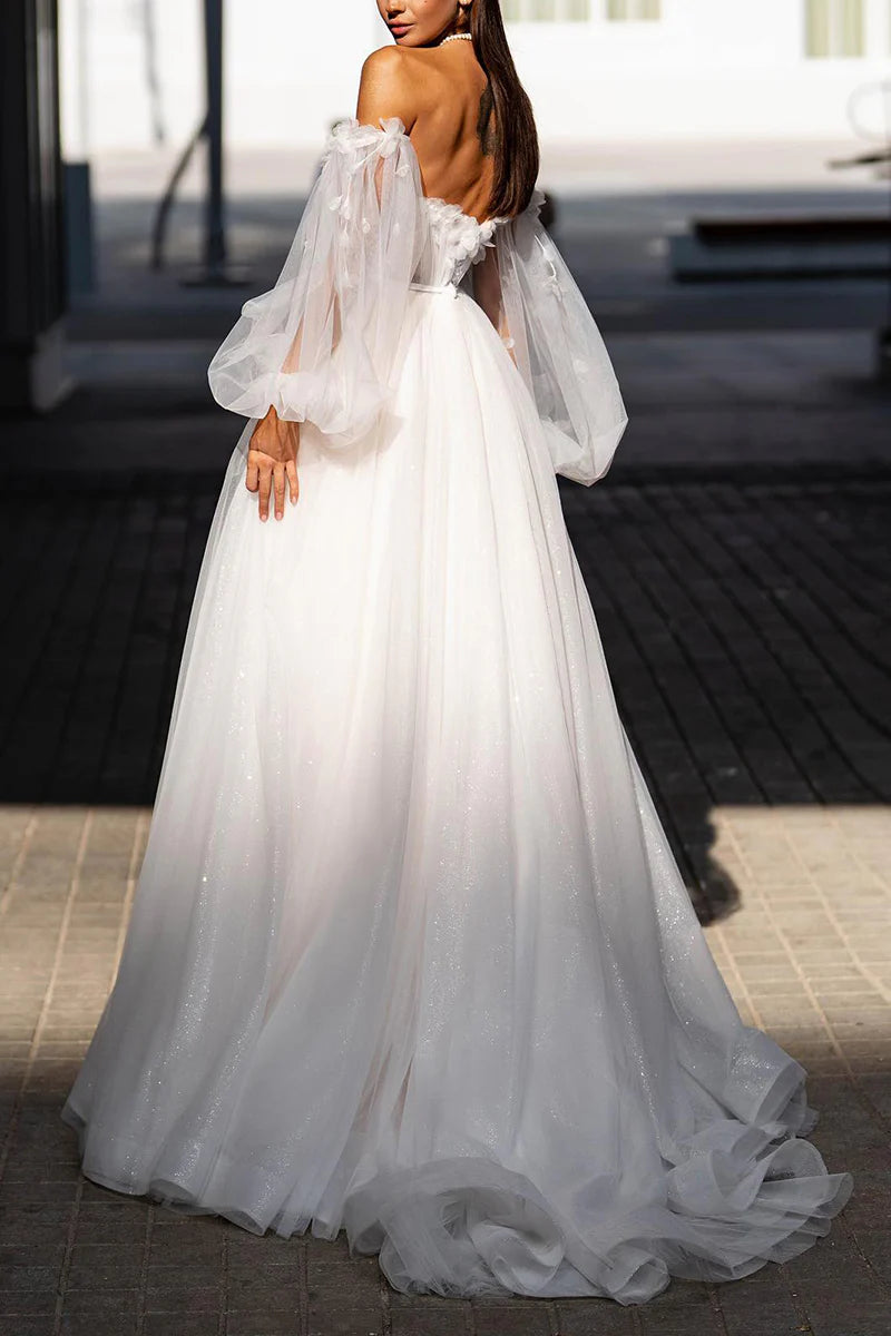 Close-up of delicate floral appliques on the long sleeve of a wedding dress.