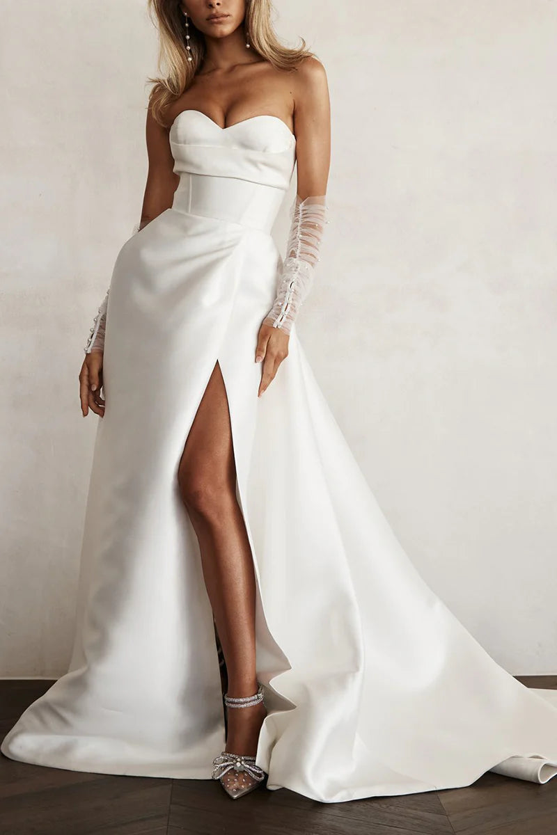 Close-up of the sweetheart neckline and long sleeves of the satin pleated wedding dress.