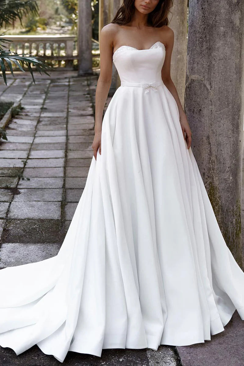 Elegant A-line sweetheart satin wedding dress with a flowing skirt.