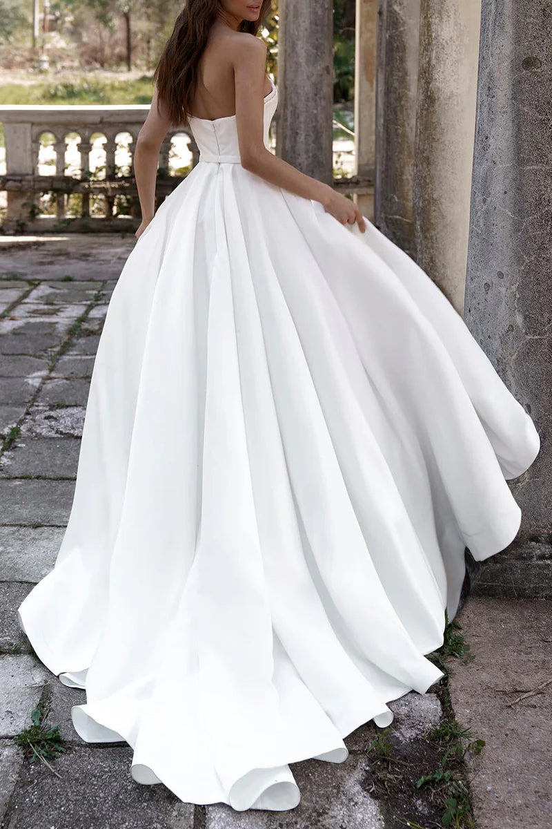 Back view of a bride wearing a sleeveless A-line satin wedding dress.