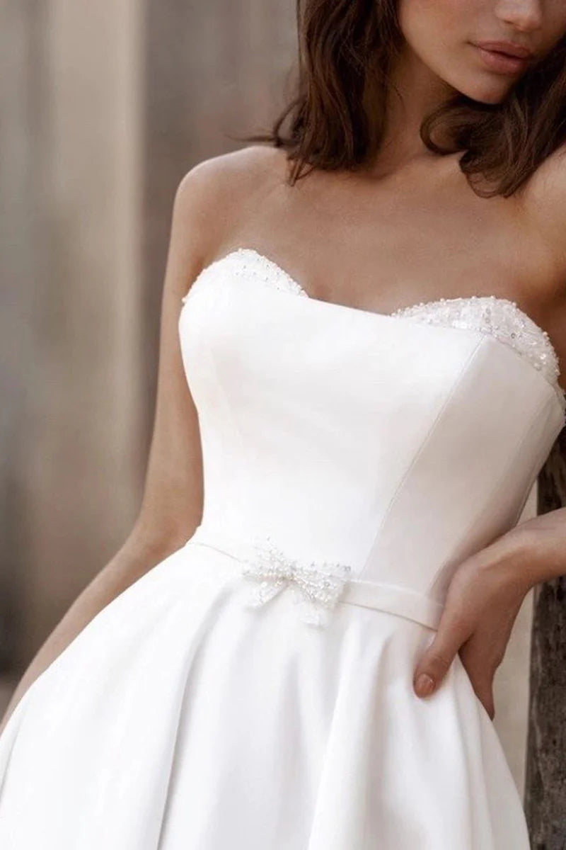 Close-up of the sweetheart neckline and satin fabric of a wedding gown.