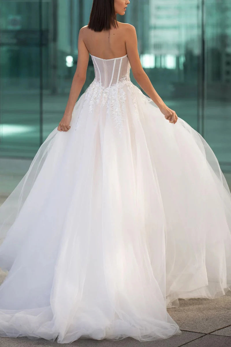 Close-up of the sweetheart neckline and intricate bead appliques on a wedding dress.