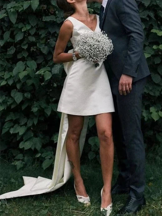 Front view of a model wearing an A-line V-neck sleeveless mini wedding dress.