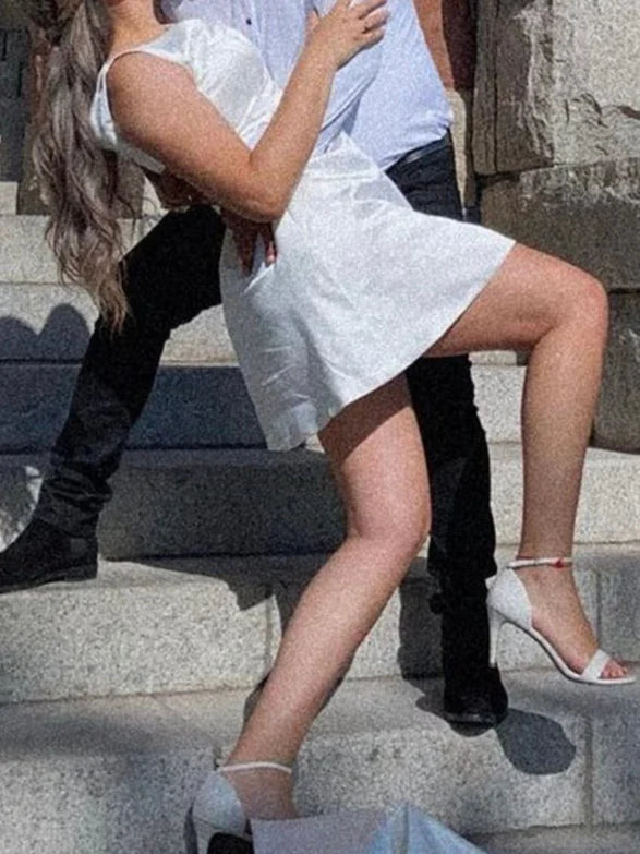 Side view of a model wearing an A-line V-neck sleeveless mini wedding dress.