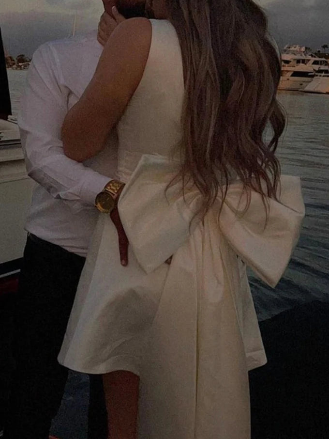 Back view of a model wearing an A-line V-neck sleeveless mini wedding dress.