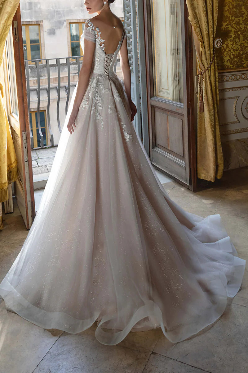 Rear view of an A-line V-neck wedding dress, showcasing lace appliques and short sleeves.