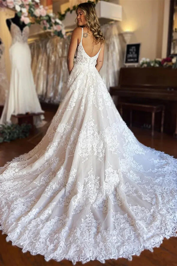 Back view of A-line tulle wedding dress featuring spaghetti straps and flowing skirt.