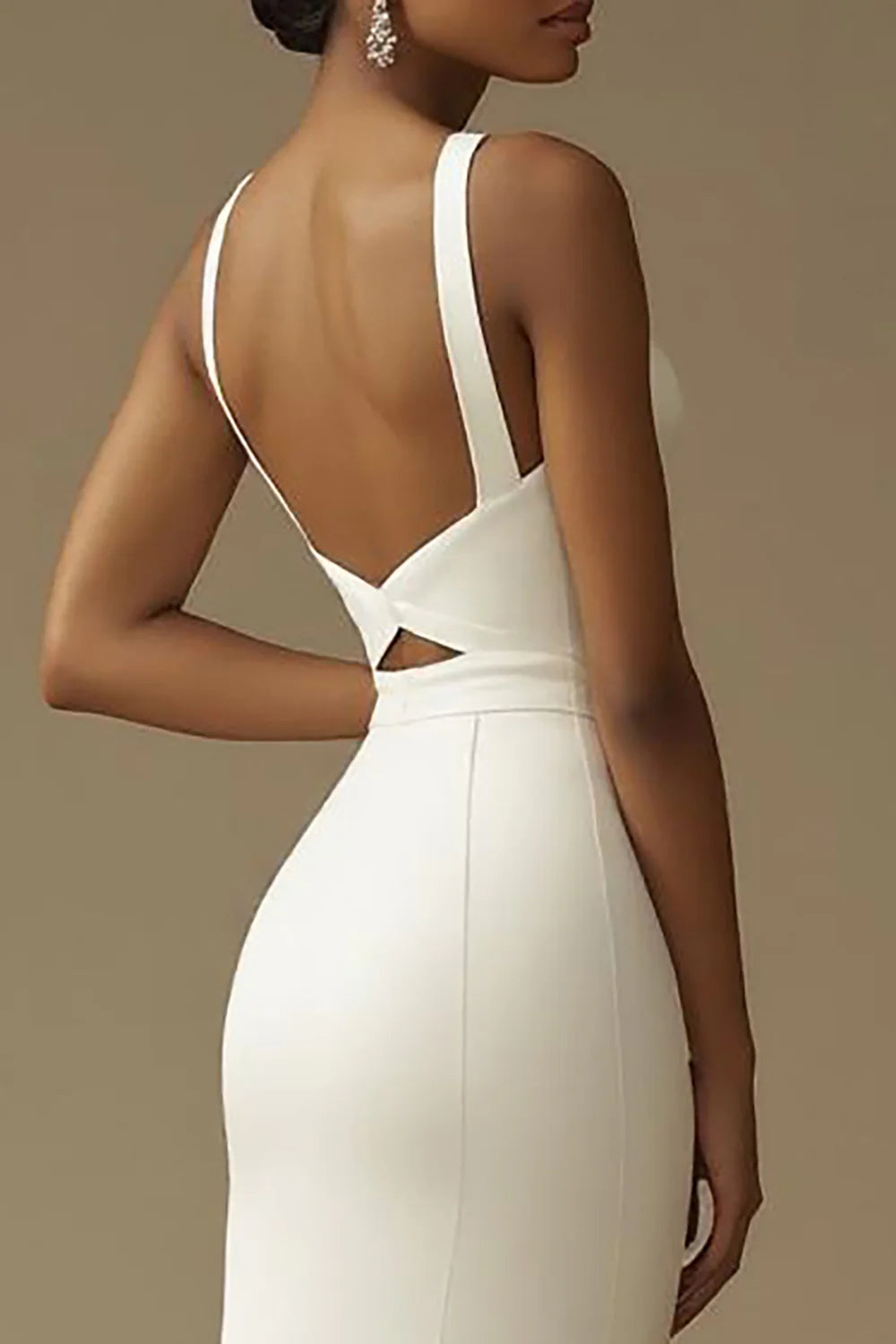 Close-up of the V-neckline and chic cut-out details on the white wedding dress.