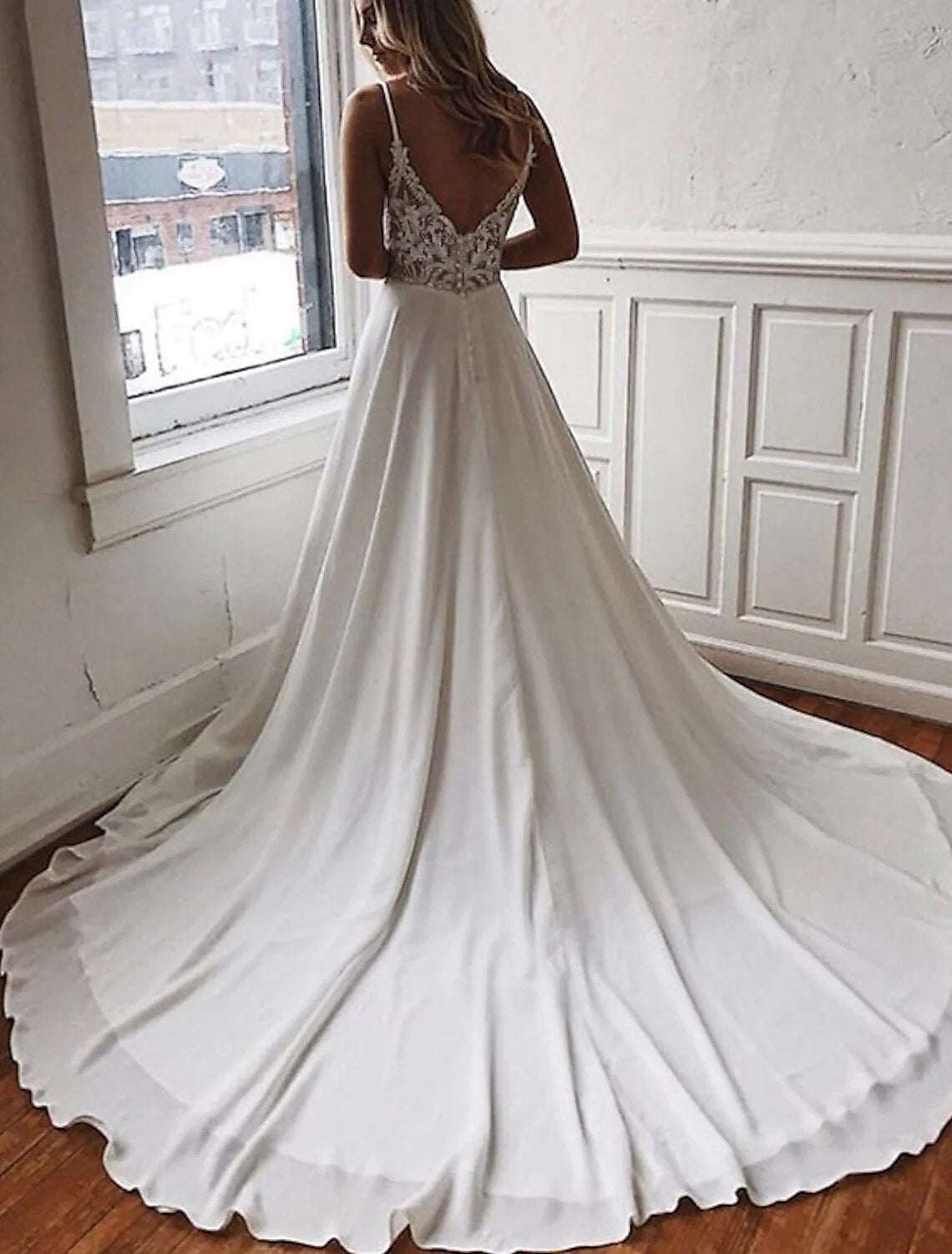 Back view of a boho wedding dress with open back and chapel train.