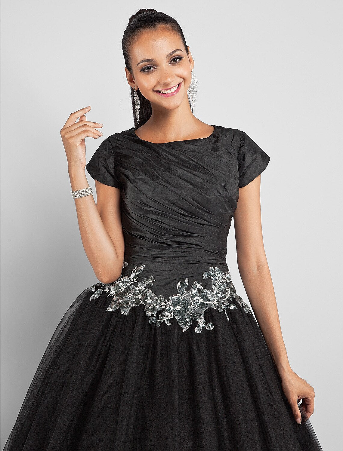 Detail of the appliques and fabric texture on the black taffeta ball gown.