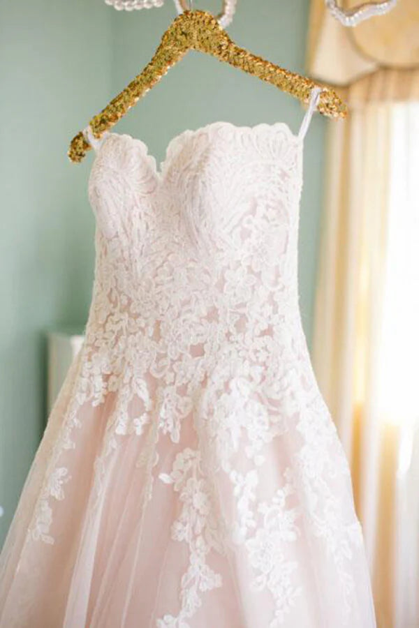 Blush pink A-line wedding dress with tulle and lace, sweetheart neckline.