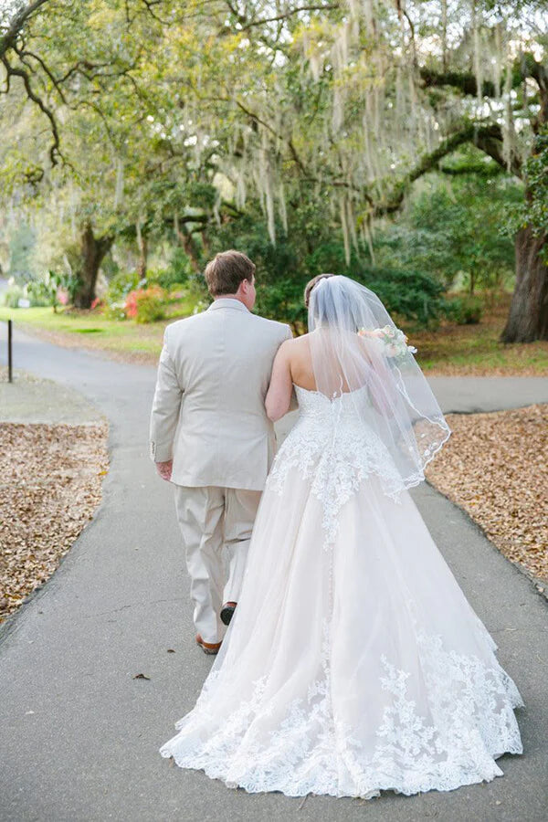 Elegant blush pink wedding dress featuring tulle and lace details.