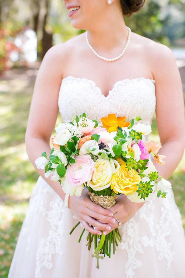 Full view of a blush pink A-line bridal gown with sweetheart neckline.