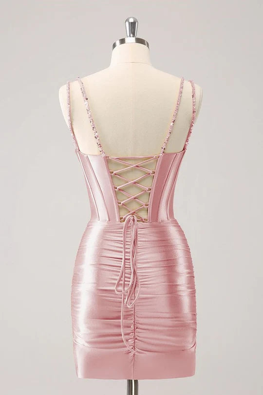 Woman wearing a blush sweetheart corset homecoming dress.