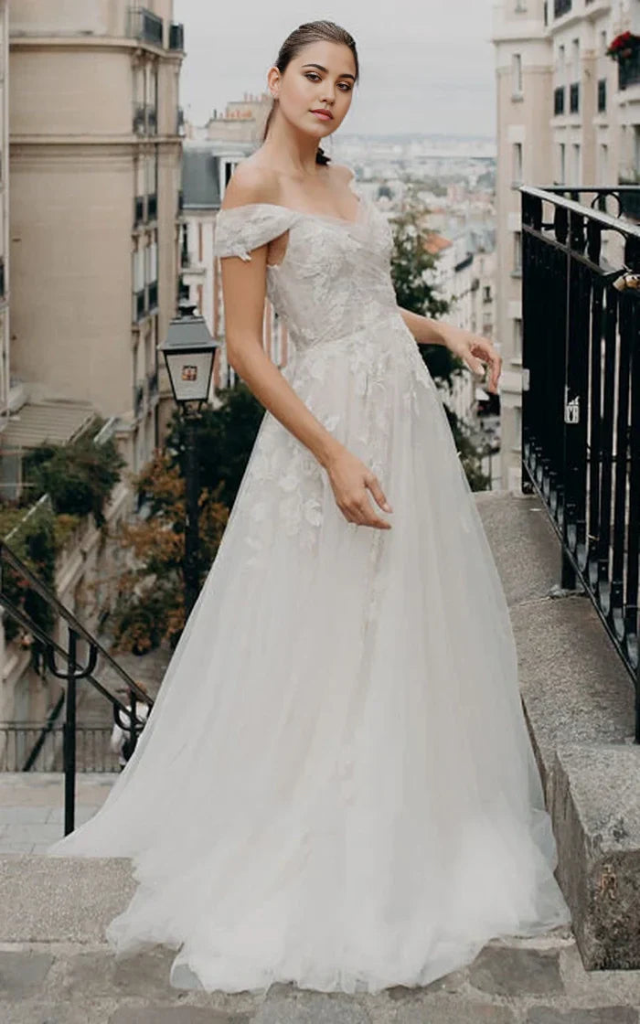 Bohemian A-line off-shoulder tulle wedding dress with appliques and short sleeves, front view.