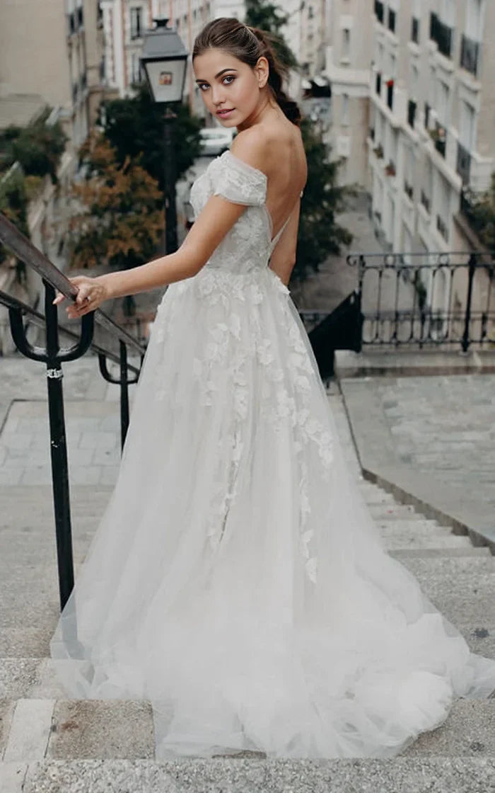 Back view of Bohemian A-line off-shoulder tulle wedding dress with brush train and appliques.