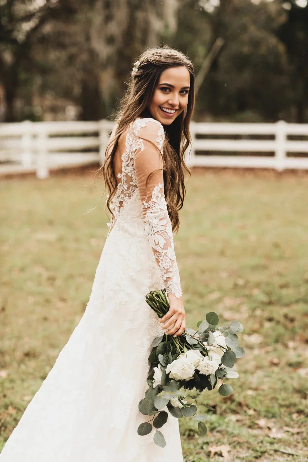 Back view of a Bohemian A-line lace wedding dress featuring a deep V-back and cathedral train.
