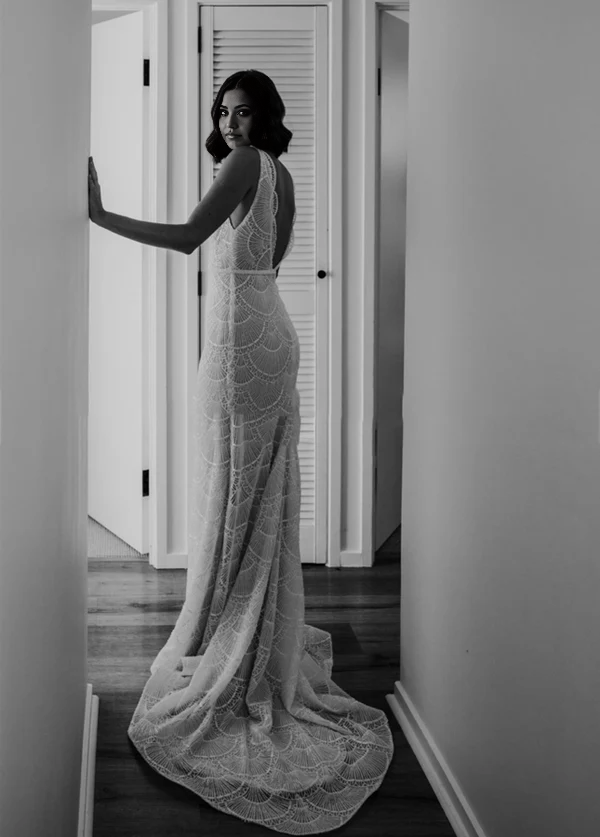Close-up of the lace detail on the backless V-neck wedding dress.