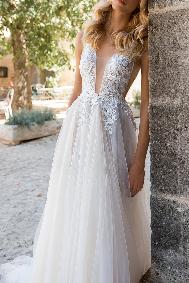 Boho A-line wedding dress with deep V-neck and lace appliques, front view.