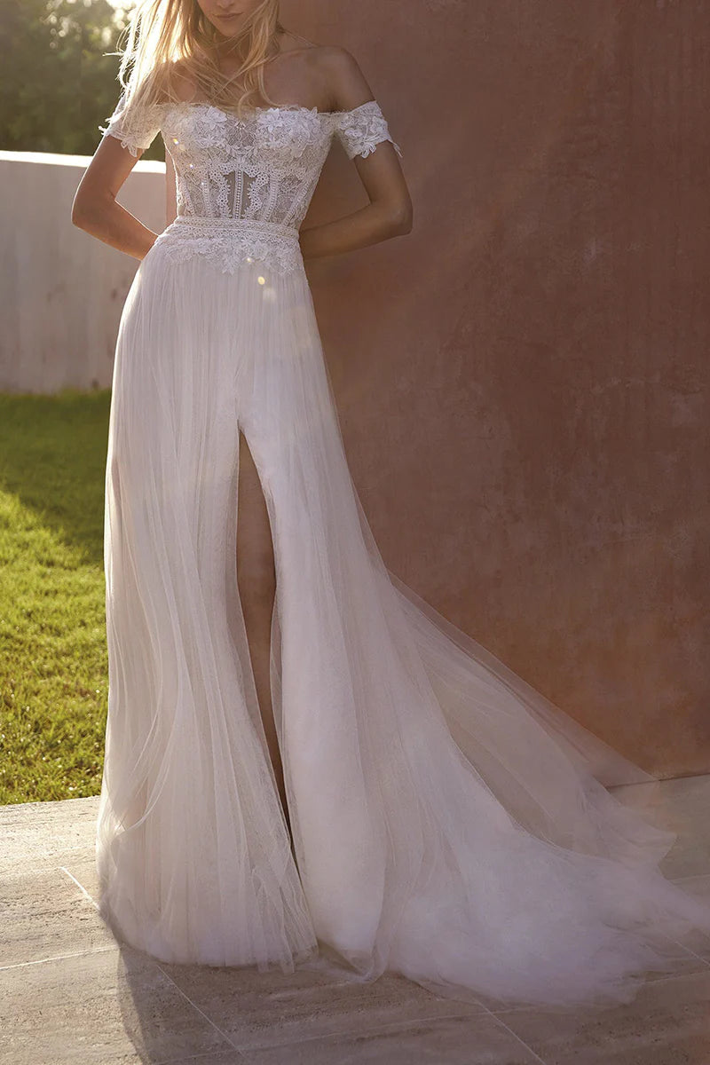 Model wearing a Boho A-line off-shoulder lace wedding dress with short sleeves and a front slit.