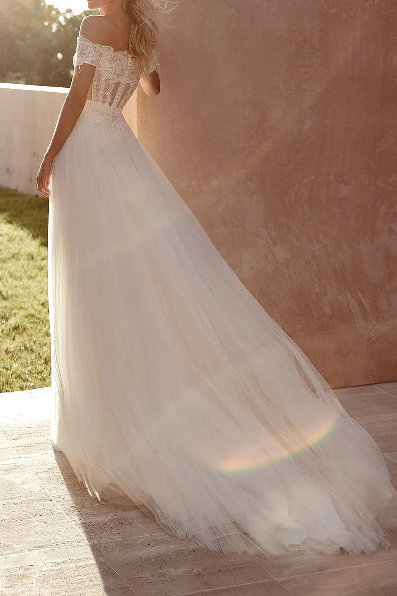 Back view of a bride in an A-line boho off-shoulder lace wedding dress, showcasing the elegant slit.