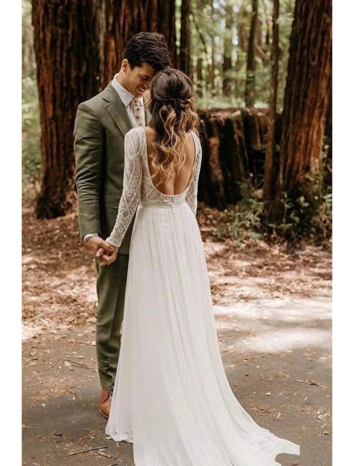 Side view of a bride wearing a lace A-line wedding dress with long sleeves.