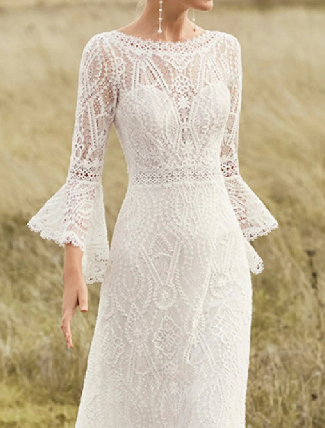 Close-up of intricate lace detail on the long sleeve of a bridal dress.