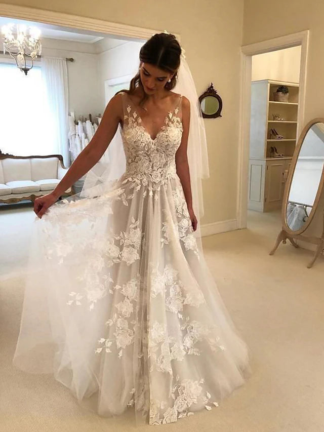 Boho A-line V-neck wedding dress with lace appliques and sweep train.