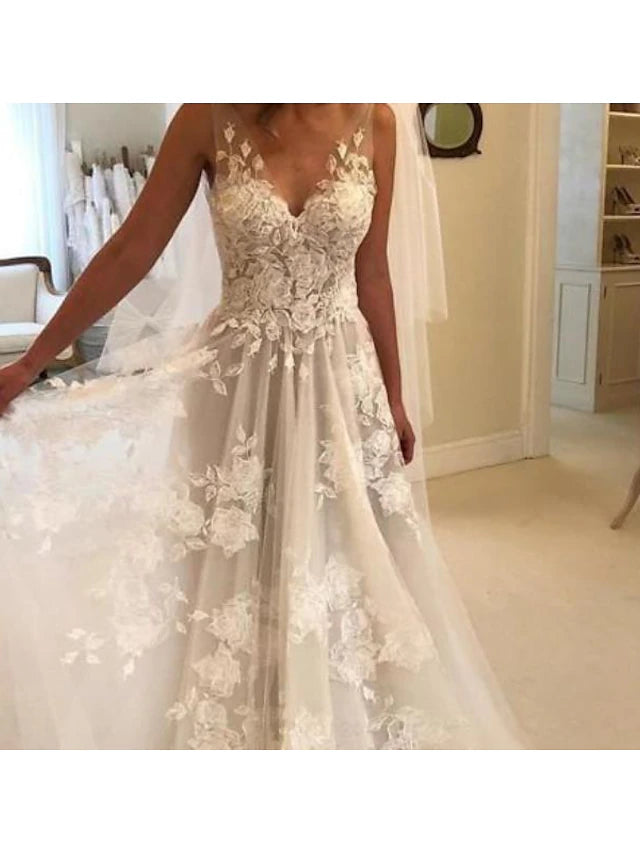 Full length view of a V-neck lace wedding dress with a sweep train.