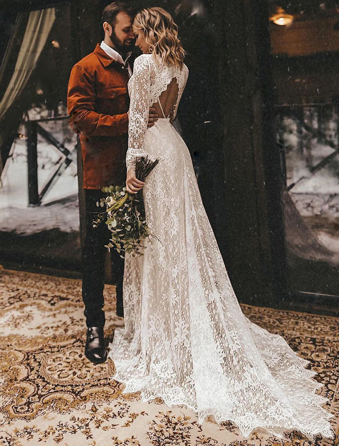 Side profile of a bride wearing an A-line lace wedding dress with a court train.
