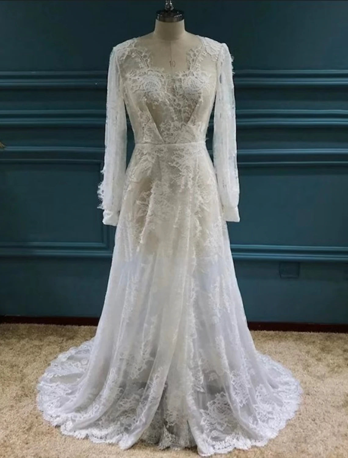 Model wearing a boho A-line V-neck long sleeve lace wedding gown with a split front.