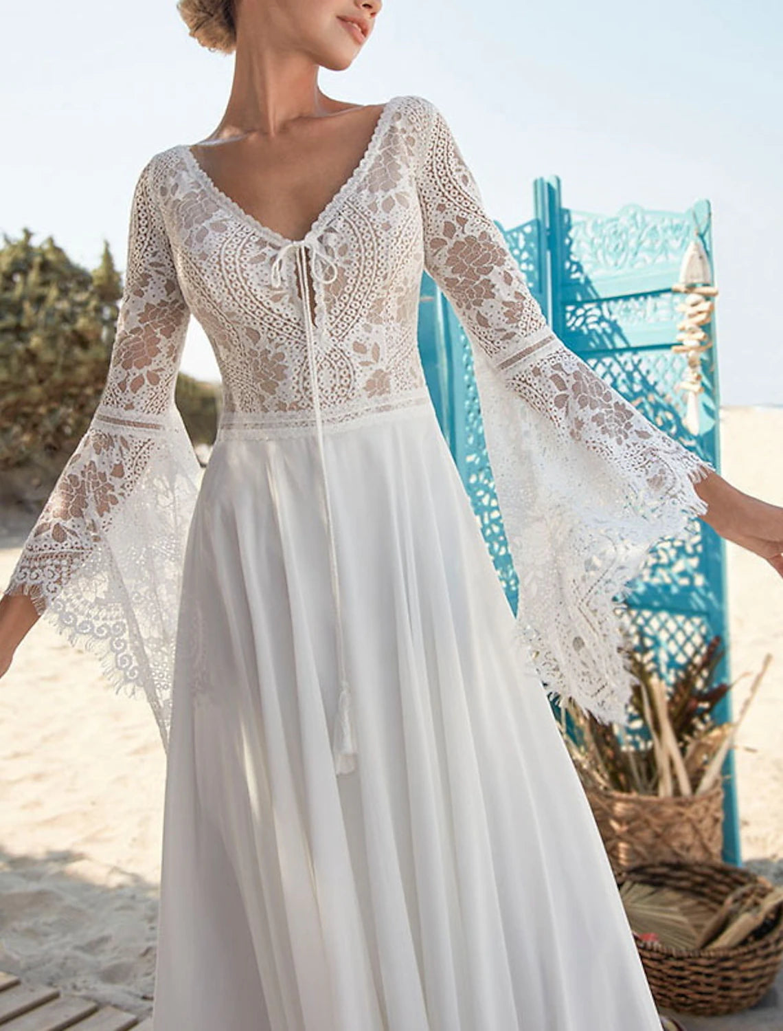 Side profile of a flowing A-line long sleeve wedding dress.