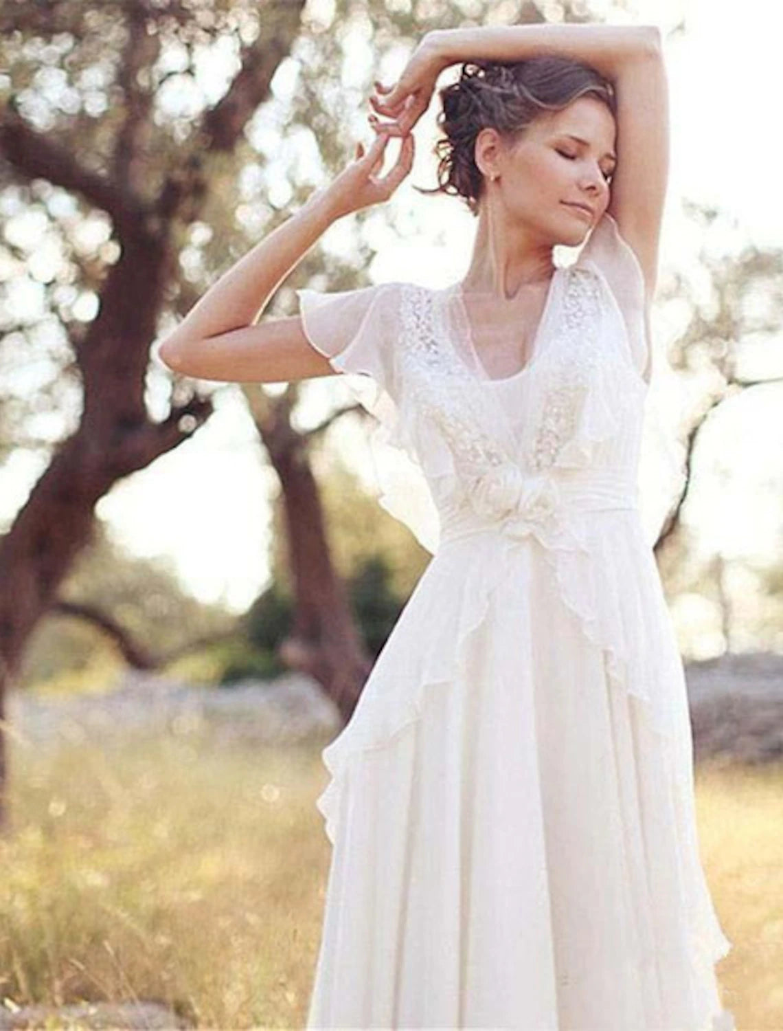 Elegant floor-length bridal gown with intricate appliques and flowing chiffon fabric.