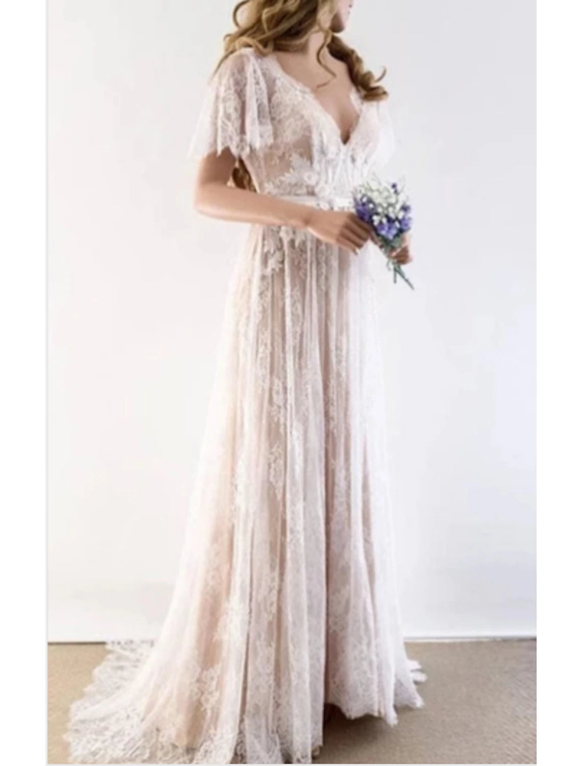 Back view of a bride wearing a lace wedding gown with a sweep train.