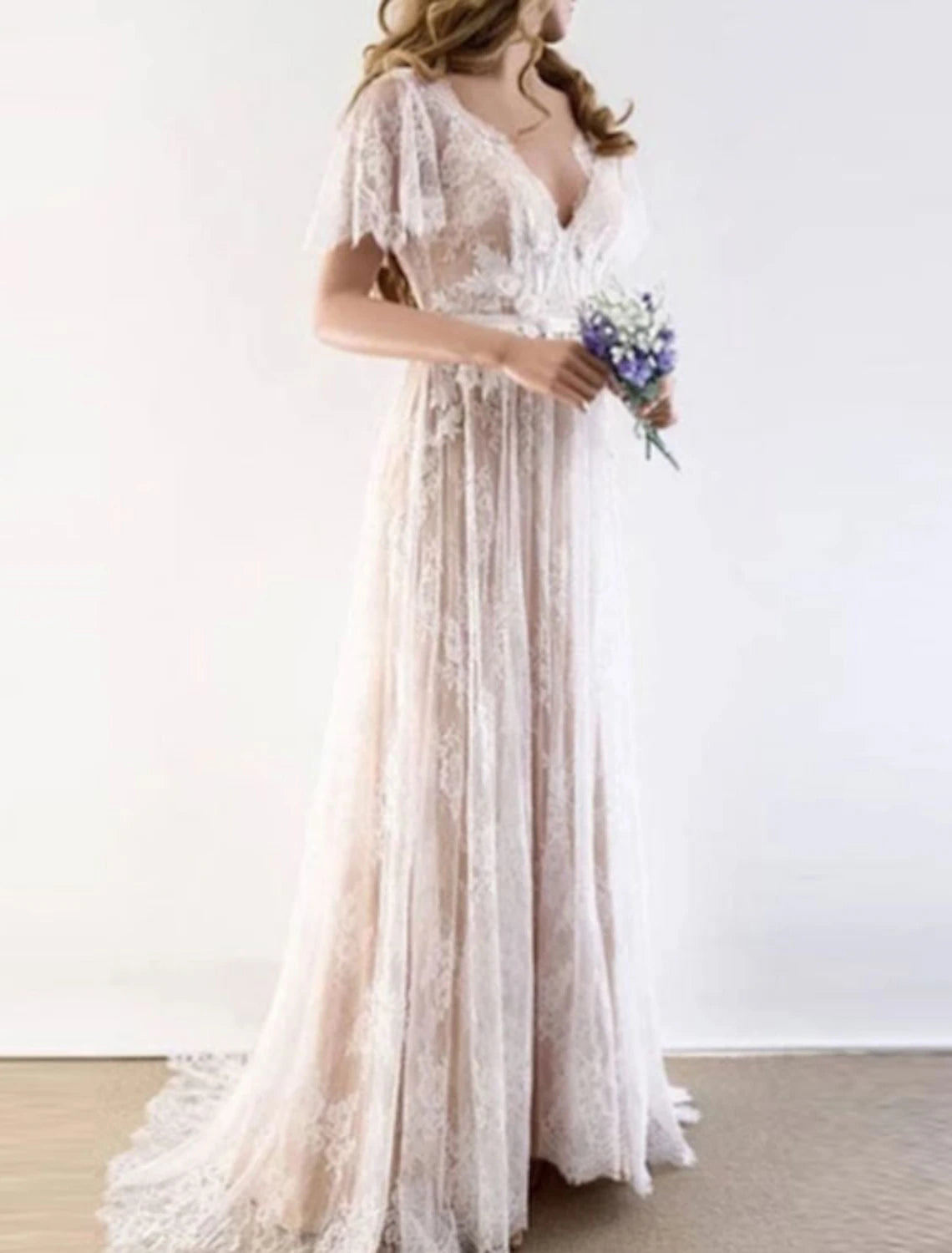 Close-up of delicate lace and draping appliques on a bridal dress.