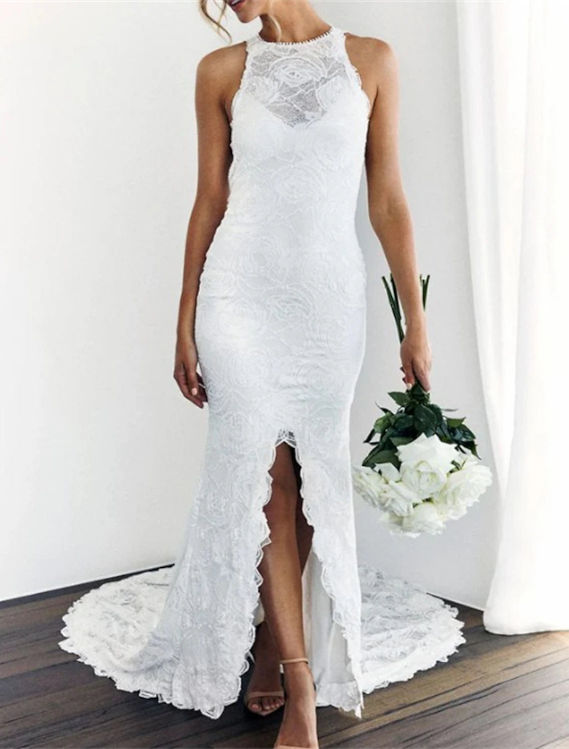 Front view of a white halter wedding dress, showcasing the mermaid silhouette and lace details.