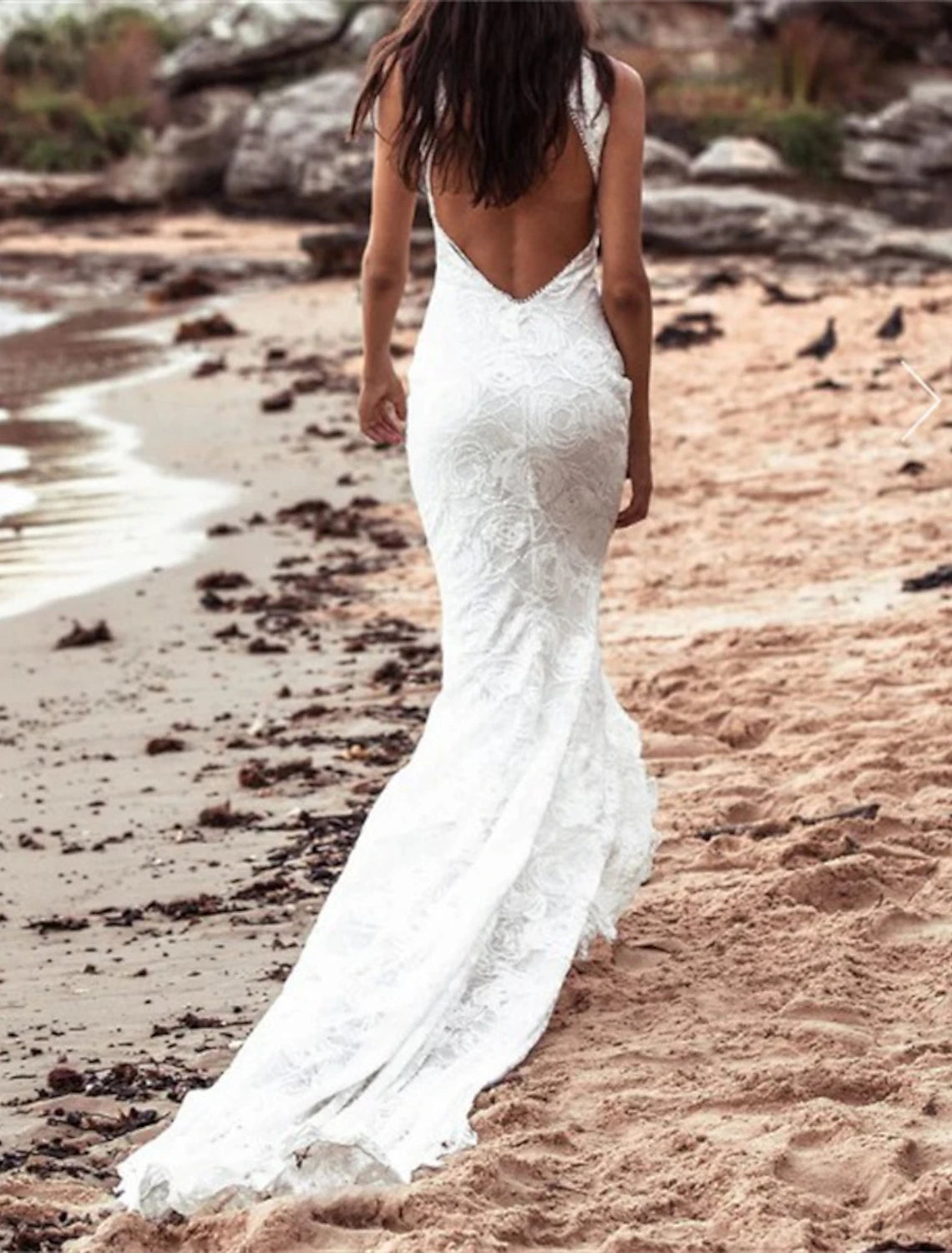 Elegant white mermaid wedding dress with a halter neck, open back, and intricate lace appliques.