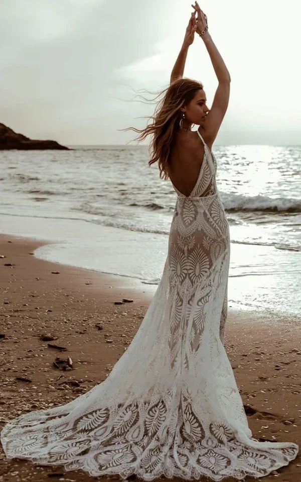 Elegant mermaid bridal gown featuring floral lace and a long sweep train.