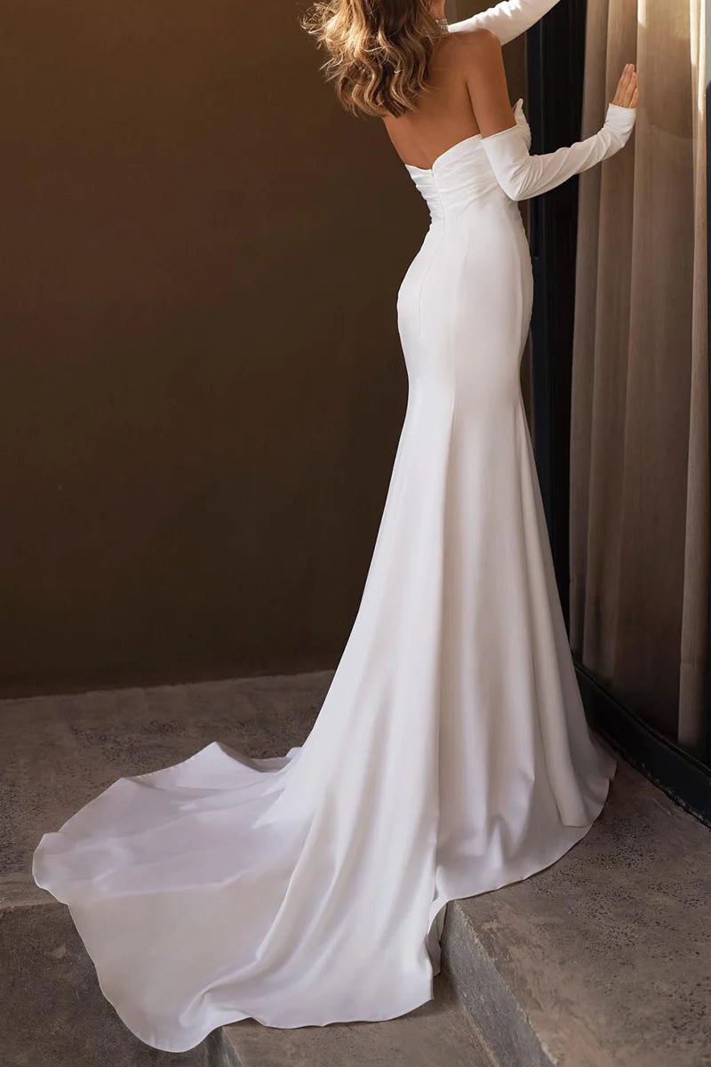 Side view of a bride wearing an elegant Strapless Mermaid Trumpet Bridal Gown, showcasing the flowing skirt and slit.