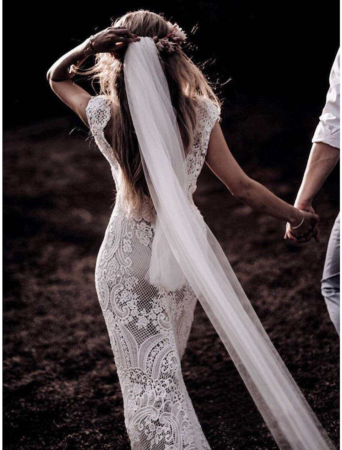 Side profile of a mermaid trumpet wedding dress with cap sleeves.